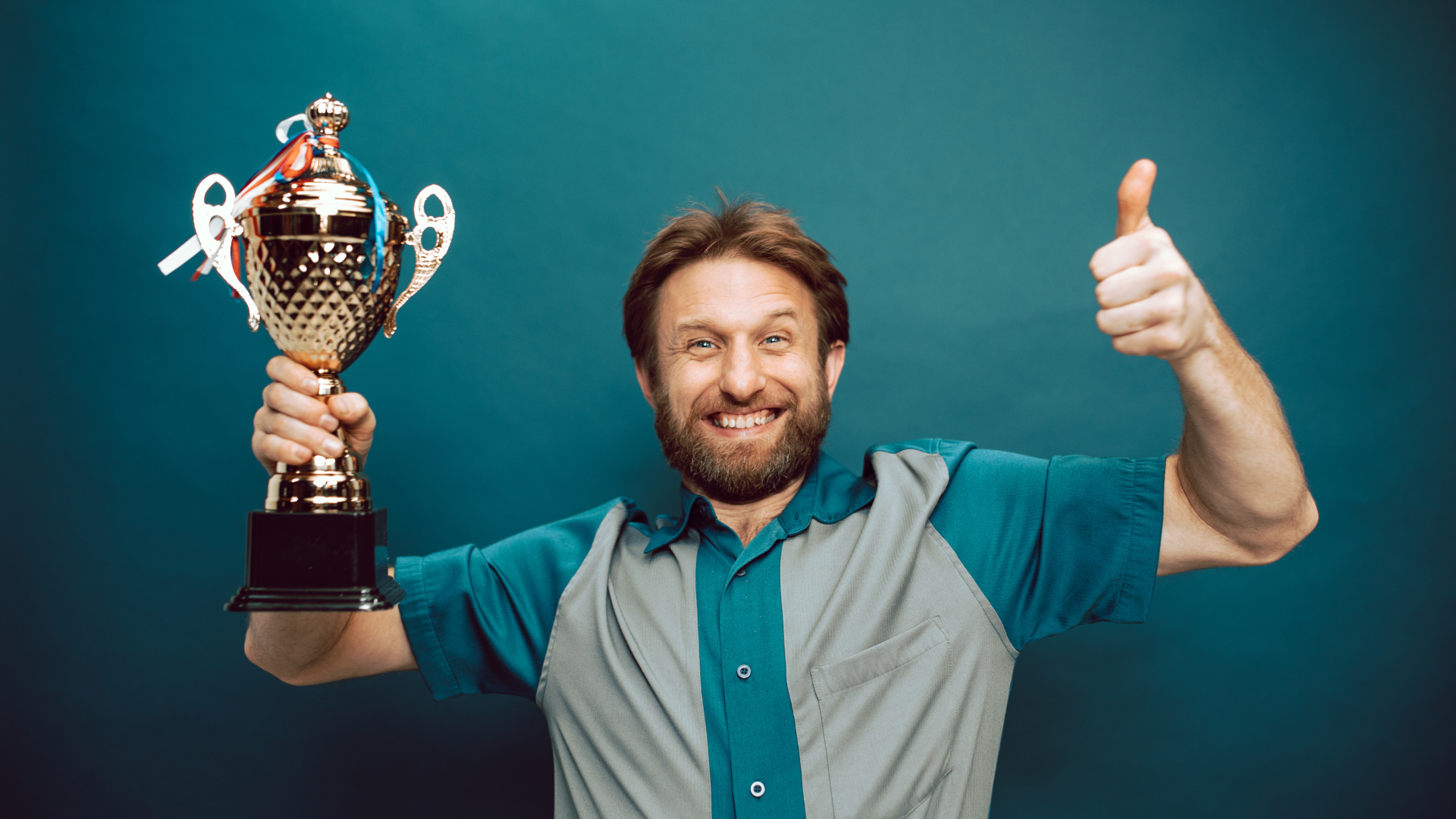 A man is happily holding his winning award for his accomplishments.